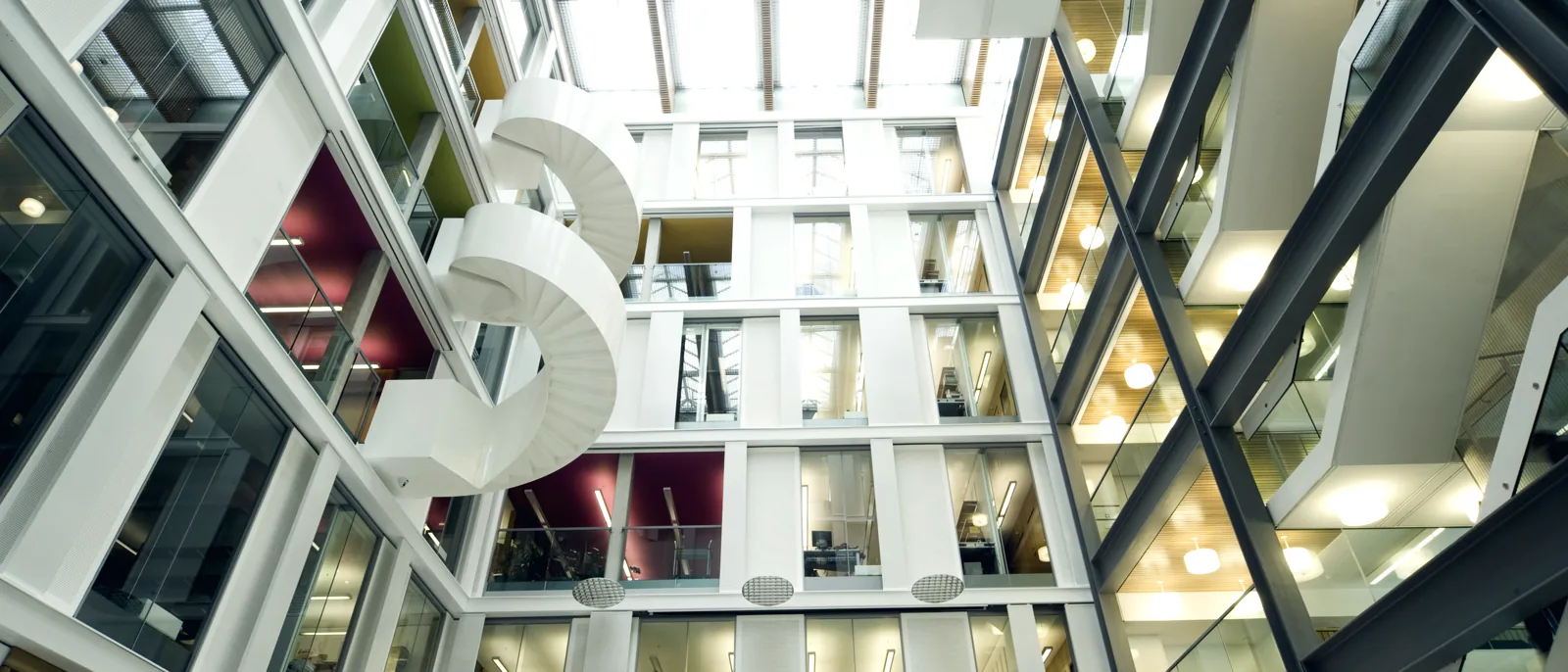 A multi-storey atrium with a spiral escape stair and glazed balustrades