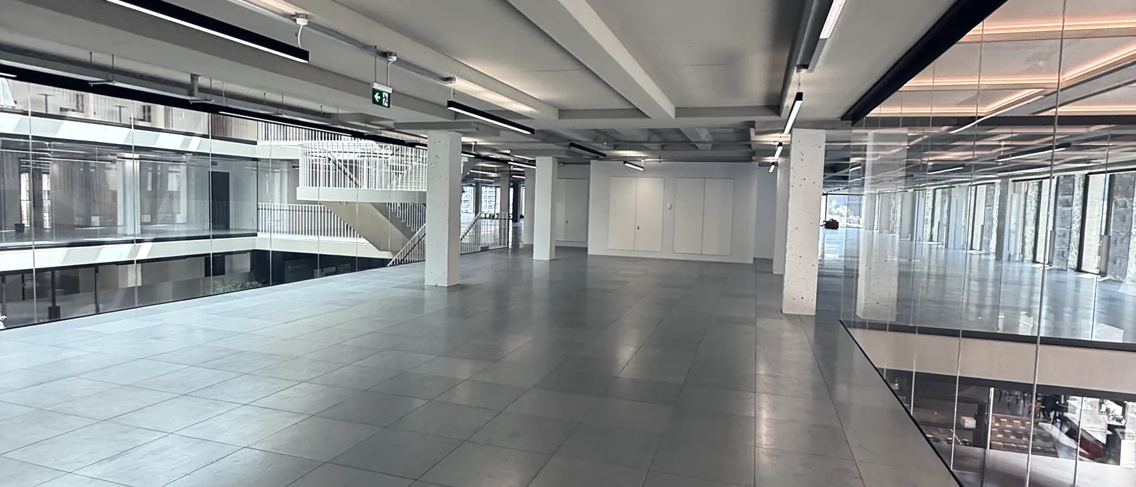 A large office atrium with open floors and walkways rising to a glazed roof